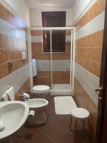 La salle de bains est pourvue de 2 toilettes et d'une douche. dans l'établissement Hotel Su Nuraxi, à Barumini