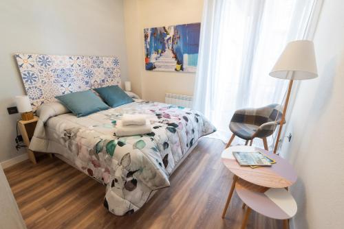 una piccola camera con letto e sedia di Albada Huesca a Huesca