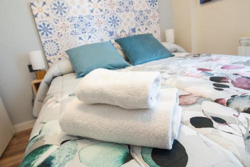 a pile of towels sitting on top of a bed at Albada Huesca in Huesca