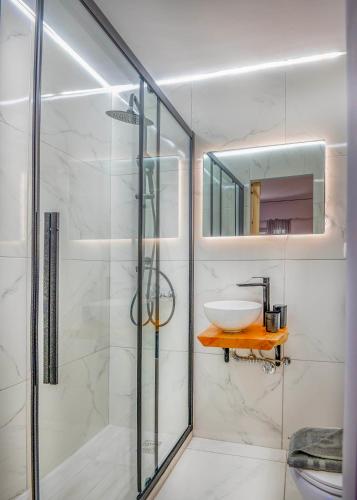 a bathroom with a glass shower and a sink at Sunny Palm Room Crete in Rethymno