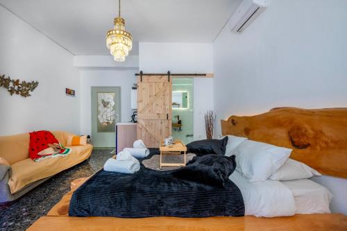 a living room with a large bed and a couch at Sunny Palm Room Crete in Rethymno