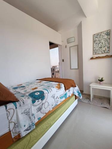 a bedroom with a bed with a comforter on it at Margarita & More, Ocean in Porlamar
