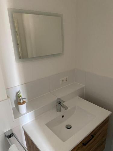 uma casa de banho branca com um lavatório e um espelho em Alte Apotheke, Apartment Nr. 3 / Thymian em Baiersbronn