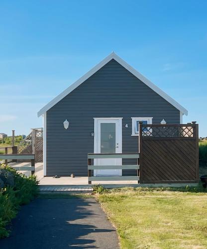 a black house with a gate in front of it at Garður Apartments in Gardur