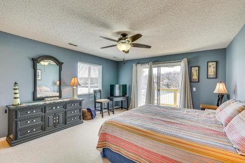 a bedroom with a bed and a dresser and a mirror at Lakefront Osage Beach Condo with Pool Access! in Osage Beach