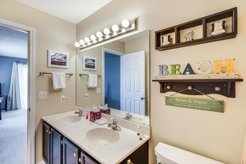 a bathroom with a sink and a mirror at Lakefront Osage Beach Condo with Pool Access! in Osage Beach