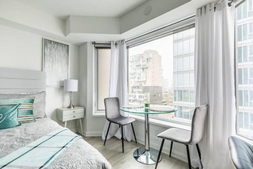 a bedroom with a bed and a table with chairs at 19th Fl Modern Studio in Yorkville in Toronto