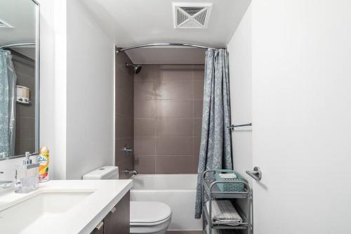 a bathroom with a sink and a toilet and a tub at 19th Fl Modern Studio in Yorkville in Toronto