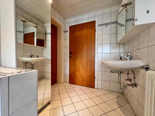 a bathroom with two sinks and a wooden door at Privathaus Sieglinde in Nußdorf
