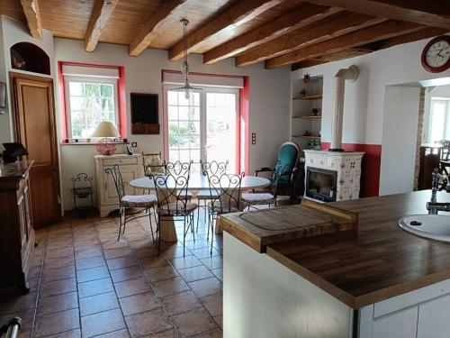 une cuisine et une salle à manger avec une table et des chaises dans l'établissement Le Moulin de Malfiance proche Futuroscope, à Doussay