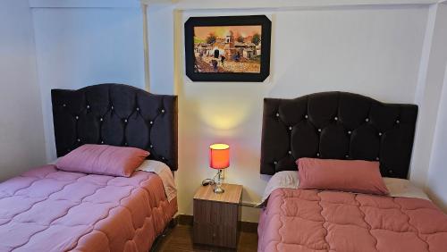 dwa łóżka siedzące obok siebie w sypialni w obiekcie Los Profesionales - Hospedaje w Cuzco