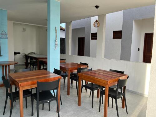 comedor con mesas y sillas de madera en Marbello Pousada Gostoso en São Miguel do Gostoso