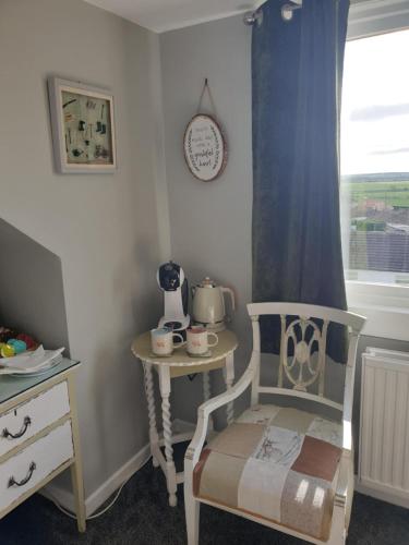 a room with a chair and a table and a window at Craigmount in Wigtown