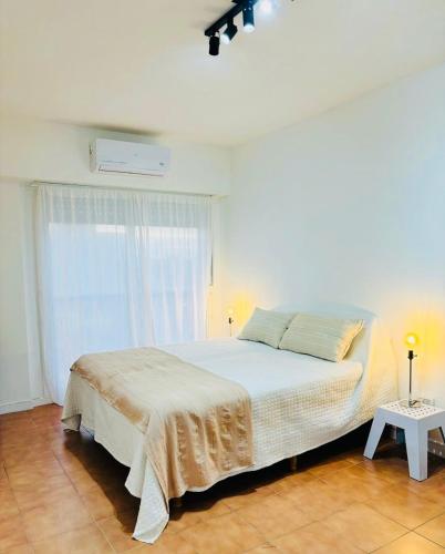 a white bedroom with a bed and a window at Monoambiente/Studio Avenida Gaona Ramos Mejía in Ramos Mejía