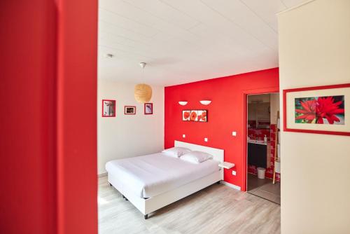 ein Schlafzimmer mit roten Wänden und einem weißen Bett in der Unterkunft Laouen Blavezh'ti in Saint-Barthélemy