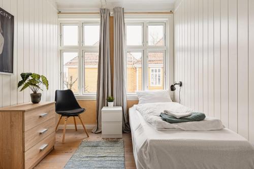 een slaapkamer met 2 bedden, een stoel en een raam bij Fit For Two Families! 8 Bedrooms! 2 Bathrooms! in Bergen