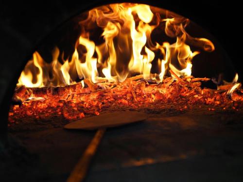 a fire oven with a bunch of flames in it at Hotel Su Nuraxi in Barùmini