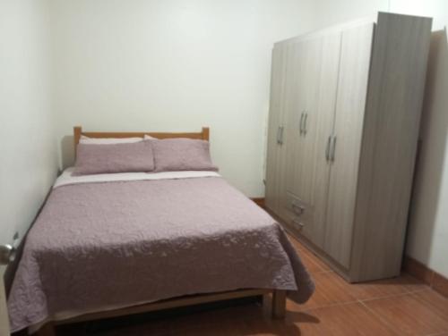 1 dormitorio con 1 cama y armario en Casa para 4-5 personas, en Lima