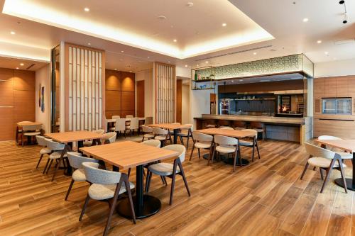 a restaurant with wooden tables and chairs at Hotel JAL City Miyazaki in Miyazaki