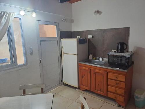 a small kitchen with a refrigerator and a sink at Temporarios Corrientes in Corrientes