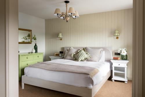 a bedroom with a large white bed and a chandelier at The Penn in Windermere