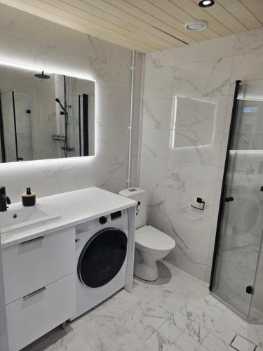 biała łazienka z toaletą i pralką w obiekcie Upea asunto Salon sydämessä, Ilmainen pysäköinti, lähellä kaikkea w mieście Salo