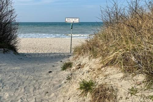 a sign in the sand on a beach at Pension Ostsee-Strand in Börgerende-Rethwisch