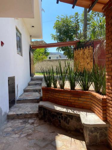 uma parede de tijolos com plantas ao lado de uma casa em Portal Malila em Tancama