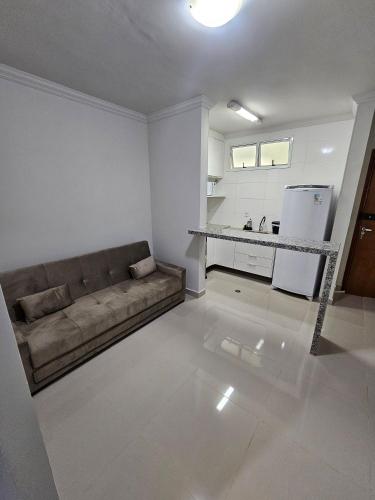 a living room with a couch and a kitchen at Edifício Belluno in Ribeirão Preto