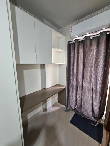 a small room with white cabinets and a curtain at Edifício Belluno in Ribeirão Preto