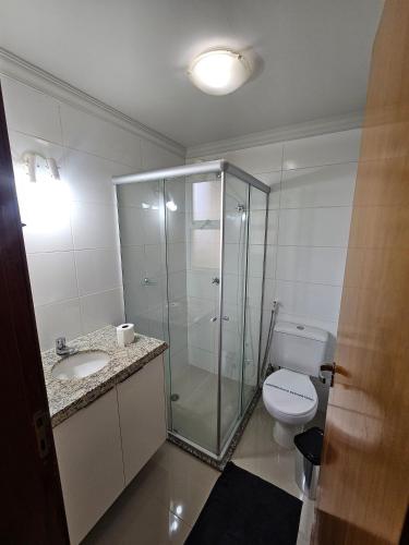 a bathroom with a glass shower and a toilet at Edifício Belluno in Ribeirão Preto