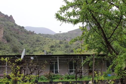 an old building with mountains in the background at Tirebi Farmhouse in Vardzia
