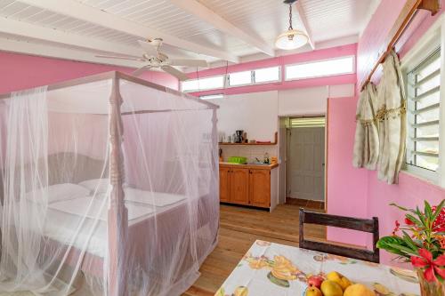 a bedroom with a bed with a mosquito net at Cabier Ocean Lodge in Crochu