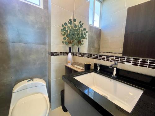 La salle de bains est pourvue de toilettes blanches et d'un lavabo. dans l'établissement APARTAMENTO PUERTO MADERA, à Manta