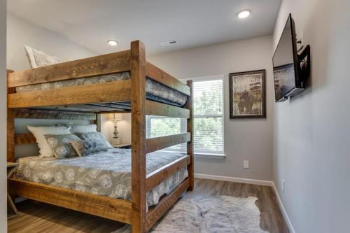 a bedroom with two bunk beds and a television at NEW Const Sleeps 6 Pool - close to Pkwy in Pigeon Forge