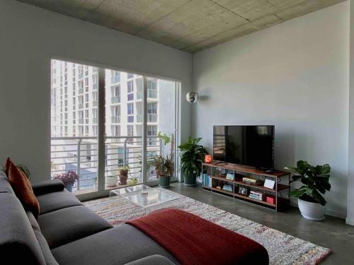 a living room with a couch and a flat screen tv at Zen Loft Downtown Miami in Miami