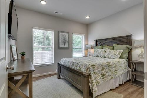 a bedroom with a bed and two windows at NEW 3 BR Apt ADA compliant Sleeps 8 in Pigeon Forge