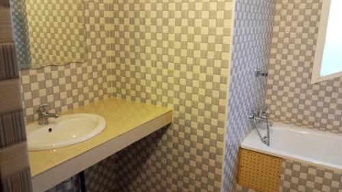 La salle de bains est pourvue d'un lavabo et d'une baignoire. dans l'établissement Al jannah Bis, à La Somone