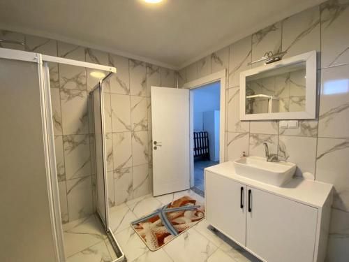 uma casa de banho com um lavatório, um espelho e um chuveiro em Mavi Boncuk em Muğla
