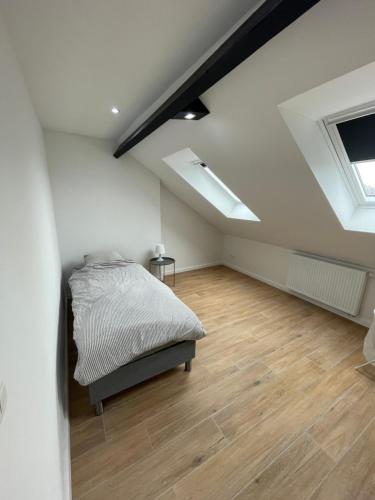 a bedroom with a bed and a wooden floor at Belle maison idéalement située in Mons