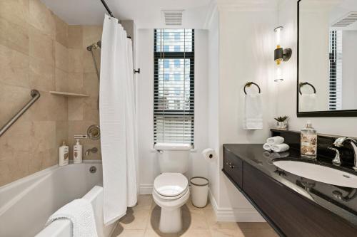 een badkamer met een wastafel, een toilet en een bad bij Elegant & Luxury 2 Bed Suite Close to Convention Centre in Vancouver