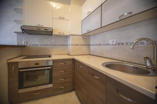 een keuken met een wastafel, een fornuis en een wastafel bij Vista Suite in Budva