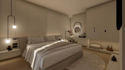 um quarto branco com uma cama grande e um espelho em PRIMO OSTUNI HOTEL em Ostuni
