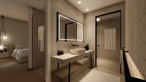uma casa de banho com um lavatório, um espelho e uma cama em PRIMO OSTUNI HOTEL em Ostuni