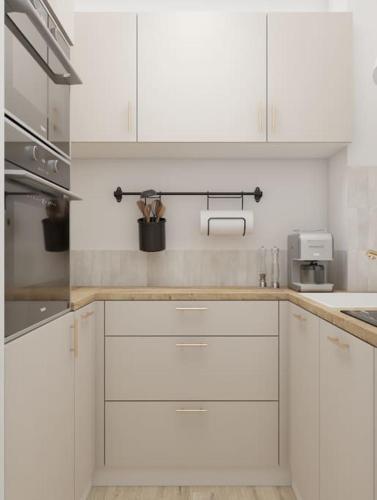 une cuisine avec des armoires blanches et un comptoir dans l'établissement ZEN & COSY - CARRÉ d'OR - Hyper centre - Plage, à Nice