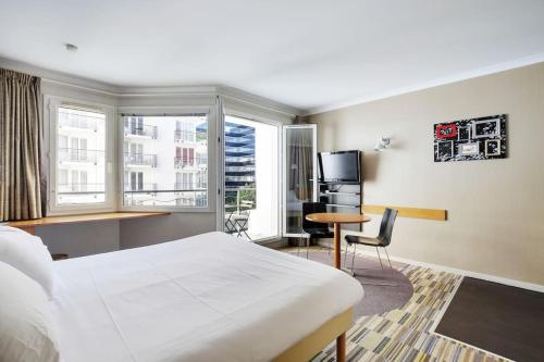 une chambre d'hôtel avec un lit, un bureau et une fenêtre dans l'établissement Le CHARMANT Paris Expo Appart'hotel Adagio 4', à Issy-les-Moulineaux