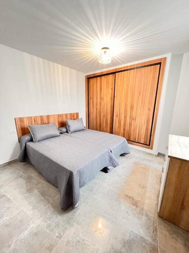 1 dormitorio con cama y ventana grande en Extenso y relajante apartamento, en Vilaflor