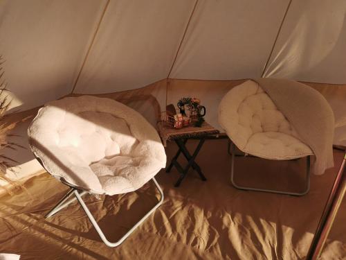 2 chaises et une table dans une tente dans l'établissement #2 Sage & Wildflower, à Drumheller