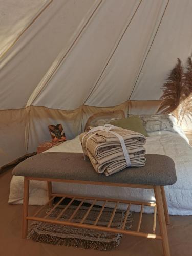 a bed in a tent with a mattress and a table at #2 Sage & Wildflower in Drumheller