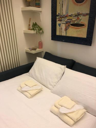 un letto bianco con due asciugamani sopra di Dimora San Fermo 11 a Verona